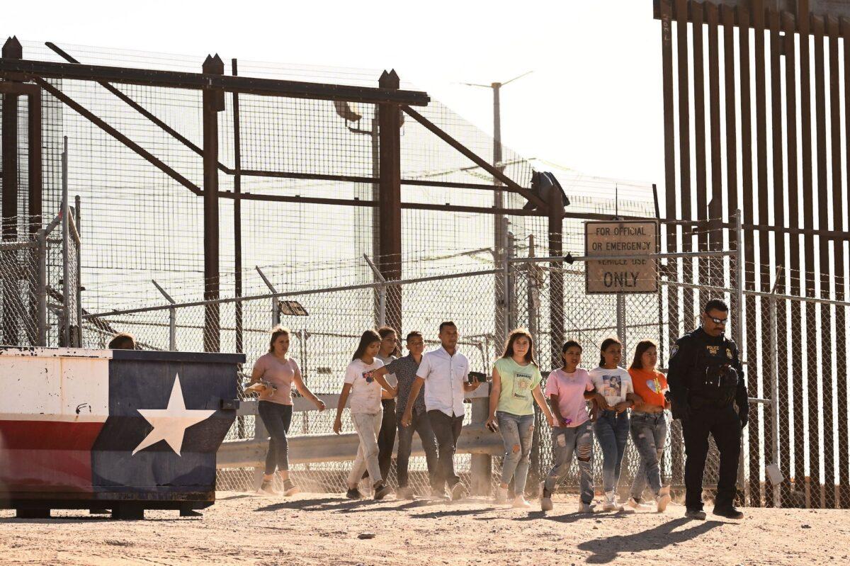 Illegal immigrants board vans after waiting along the border wall to surrender to U.S. Customs and Border Protection (CBP) Border Patrol agents near the Rio Grande River into the United States on the U.S.-Mexico border in El Paso, Texas, on May 11, 2023. (Patrick T. Fallon/AFP via Getty Images)