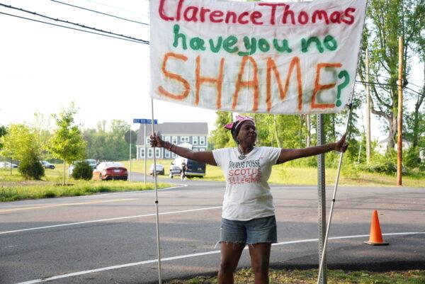 Protestor Nadine Seiler holds up a banner during an abortion protest near the home of Justice Clarence Thomas on May 11. (Joseph Lord/The Epoch Times)