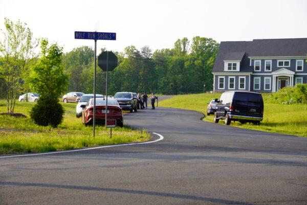 A contingent of Fairfax County police officers stands by on the other side of the road during a protest near the home of Justice Clarence Thomas on May 11. (Joseph Lord/The Epoch Times)