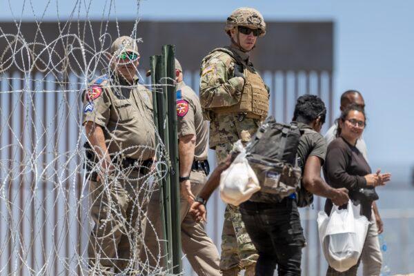 A Texas National Guard soldier watches as an illegal immigrant walks into a makeshift camp in El Paso, Texas, on May 11, 2023. (John Moore/Getty Images)