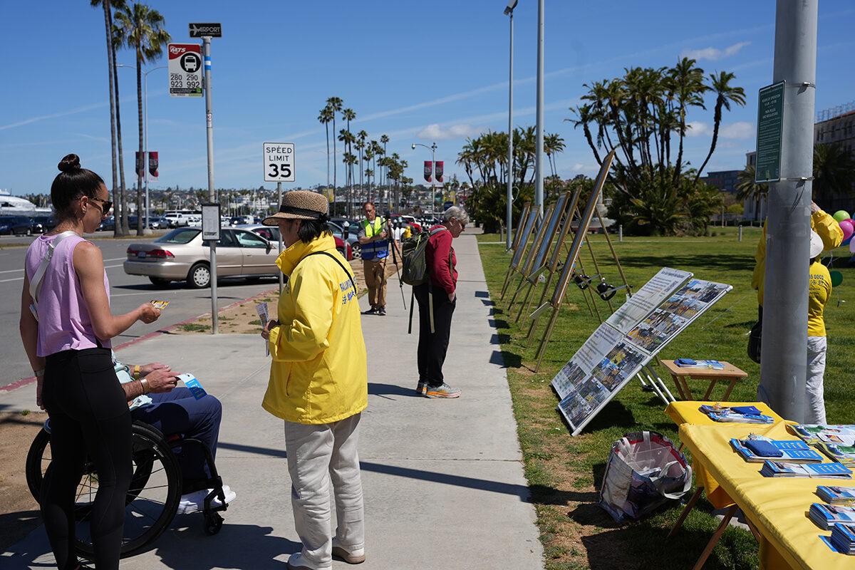 Members of the spiritual practice Falun Dafa hand out fliers as they celebrate World Falun Dafa Day at the San Diego County Administration building in Downtown San Diego on May 7, 2023. (Jane Yang/The Epoch Times)