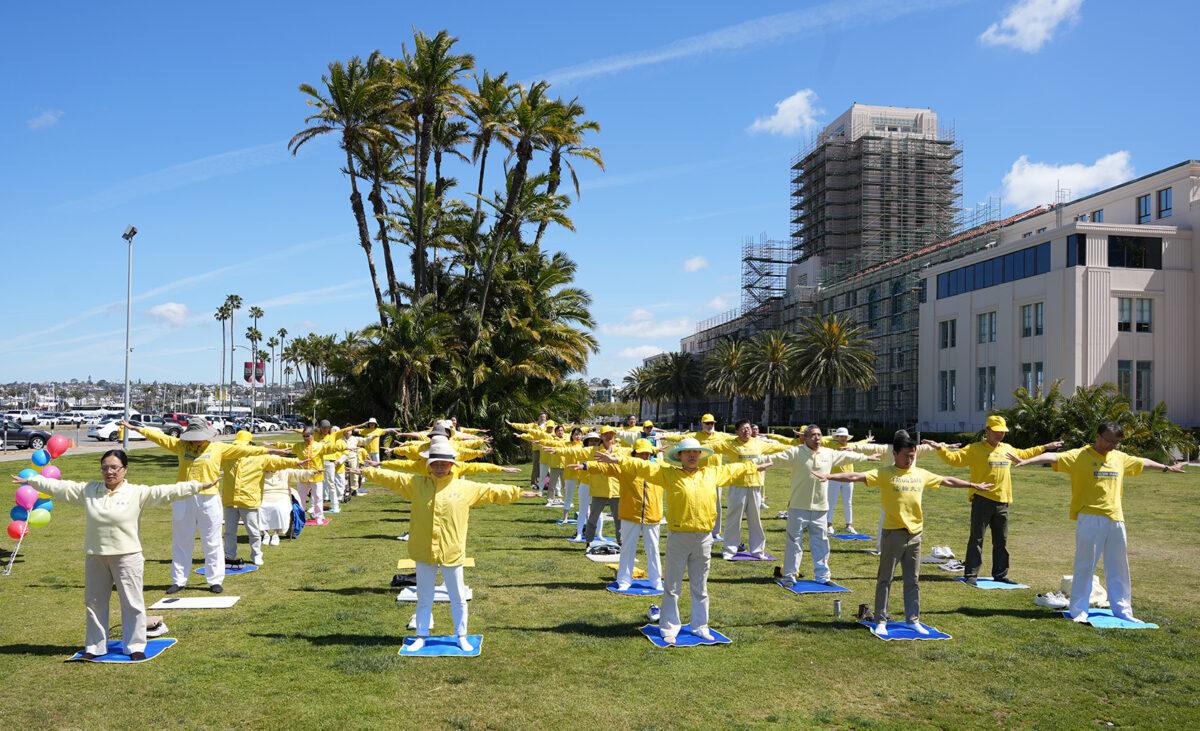 Members of the spiritual practice Falun Dafa demonstrate the practice's exercises as they celebrate World Falun Dafa Day at the San Diego County Administration building in Downtown San Diego on May 7, 2023. (Jane Yang/The Epoch Times)