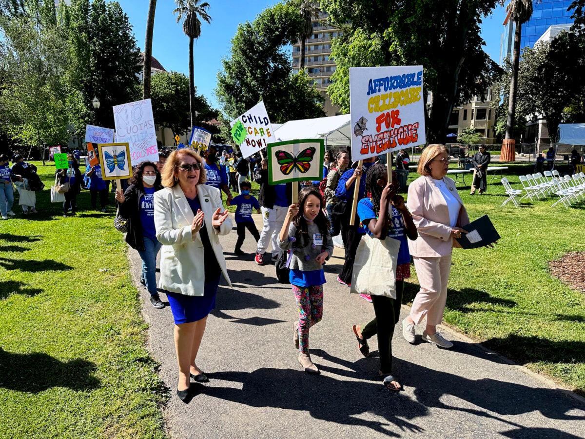California Assembly Majority Leader Eloise Gomez Reyes (L) and Democratic Assemblywoman Cecilia Aguiar-Curry (R) march with parents and others who support the state's subsidized childcare programs in Sacramento on May 10, 2023. (AP Photo/Adam Beam).