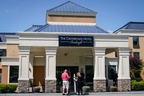 Security stands at the doors of The Crossroads Hotel, where two busloads of illegal immigrants arrived hours earlier in Newburgh, N.Y., on May 11, 2023. (John Minchillo/AP Photo)