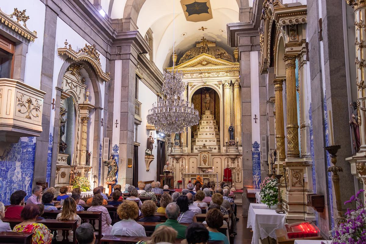 A congregation sits during a service amid ornate architecture in the interior of Chapel of Souls. (agsaz/Shutterstock)