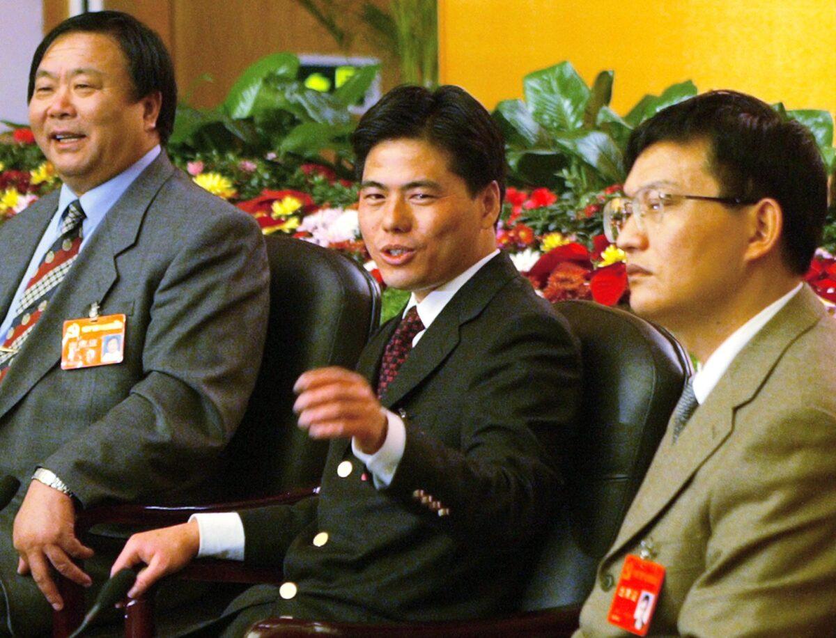 Businessman and Communist Party member Jiang Xipei (C) is flanked by Zan Shengda (R), ranked 39th on the Forbes list of top 100 richest people in China, and Shen Wenron, who is ranked 39th on the Forbes list, at a press conference at the 16th Communist Party Congress in Beijing on Nov. 11, 2002. (Peter Parks/AFP via Getty Images)