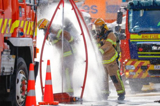Firefighters rinse off after a fire at Loafers Lodge in Wellington, New Zealand on May 16, 2023. (Hagen Hopkins/Getty Images)
