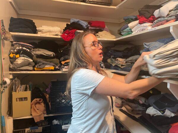 Homeless program volunteer Staci Loveridge distributes clothing from the men’s closet to those in need at Saint Luke’s Episcopal Church in Long Beach, Calif., on May 13, 2023. (Carol Cassis/The Epoch Times)