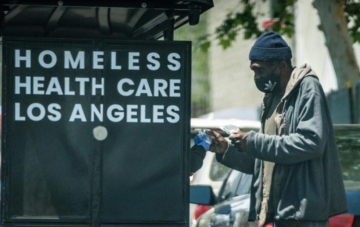 Homeless Health Care Los Angeles workers distribute items in the Skid Row neighborhood of Los Angeles on May 16, 2023. (John Fredricks/The Epoch Times)