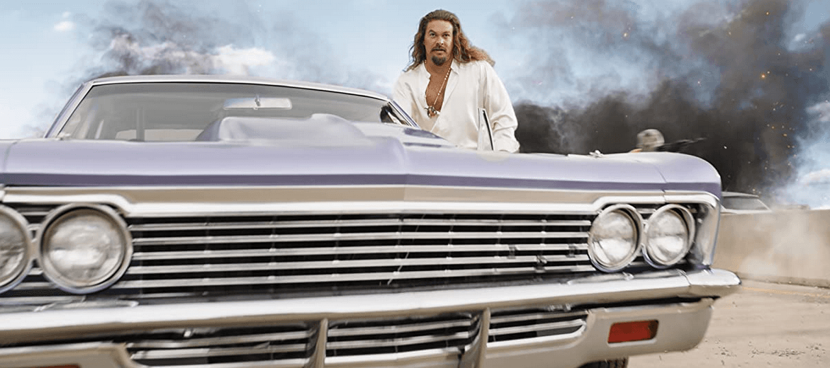 Dante Reyes (Jason Momoa) with his lavender '66 Chevy Impala, in “Fast X." (<a href="https://www.imdb.com/title/tt5433140/mediaviewer/rm3685818881?ft0=name&fv0=nm0597388&ft1=image_type&fv1=still_frame" target="_blank" rel="noopener">Universal Pictures</a>)