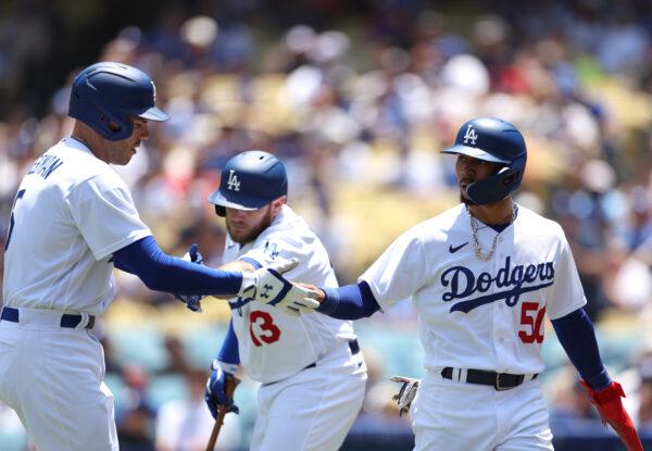 Mookie Betts (50) of the Los Angeles Dodgers celebrates his run with Freddie Freeman (5), and Max Muncy (13), to take a 1–0 lead over the Minnesota Twins, during the third inning at Dodger Stadium in Los Angeles on May 17, 2023. (Harry How/Getty Images)