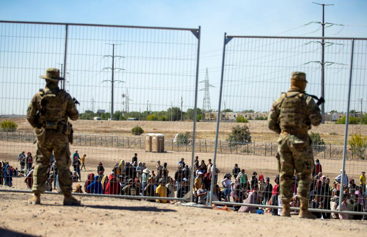Texas National Guard troops watch over illegal immigrants tin El Paso, Texas, on May 10, 2023. (Andres Leighton/AP Photo)