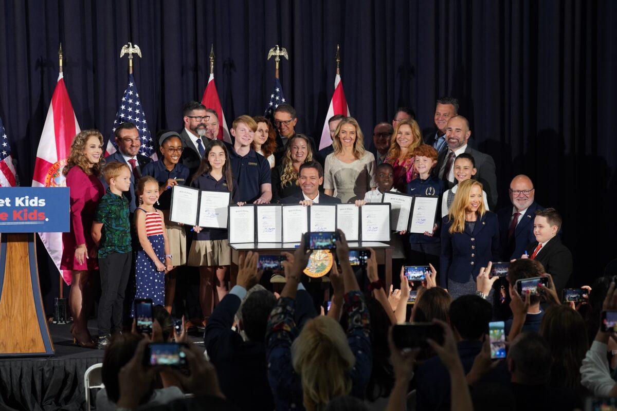 Florida Gov. Ron DeSantis shows off five bills to "let kids be kids" and protect women's sports at a ceremony in Tampa on May 17, 2023. (Courtesy of Florida Governor's Office)