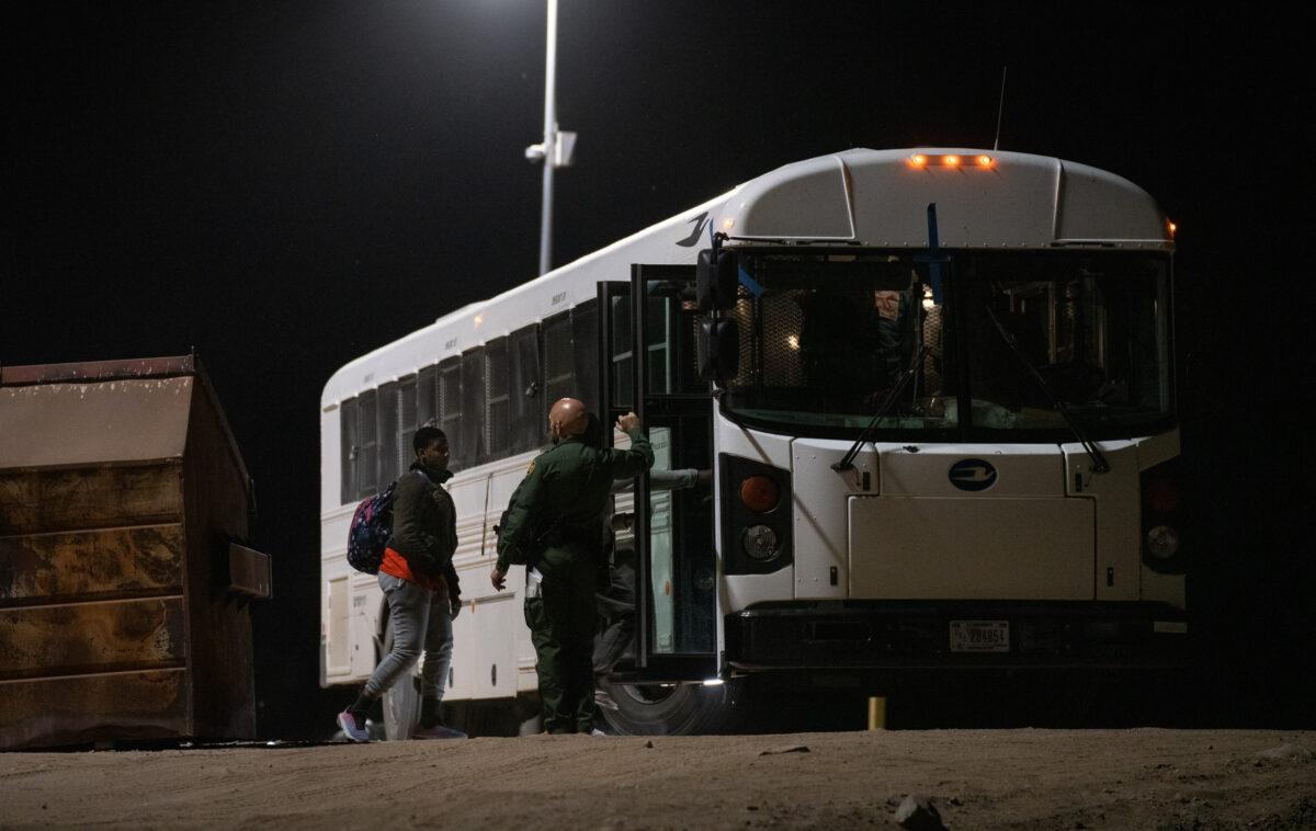 Illegal immigrants prepare to be transported by bus to processing facilities in Yuma, Ariz., on May 18, 2023. (John Fredricks/The Epoch Times)