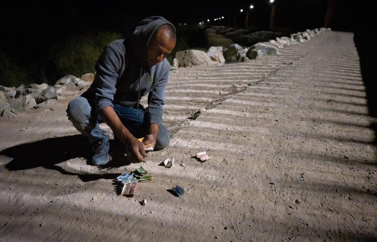 "David" from Mexico displays the money he's collected left behind by migrants crossing into Yuma, Ariz., on May 18, 2023. (John Fredricks/The Epoch Times)