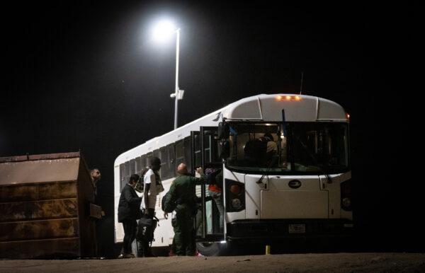 Illegal immigrants prepare to be transported by bus to Border Patrol processing facilities in Yuma, Ariz., on May 18, 2023. (John Fredricks/The Epoch Times)