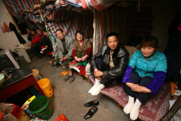 Four migrant worker couples sit in their shelters made out of plastic sheeting, at a road construction site in Chongqing municipality, China, on March 5, 2008. (China Photos/Getty Images)