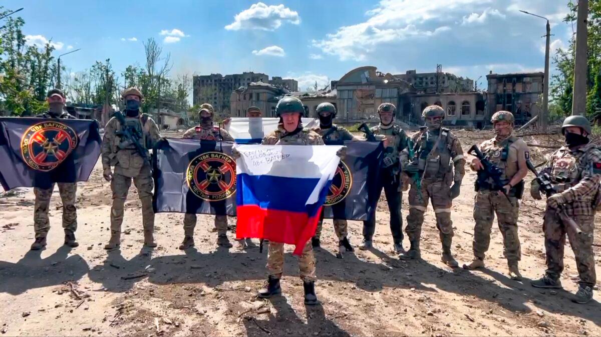 Yevgeny Prigozhin, head of the Wagner Group military company, holds a Russian national flag in front of his soldiers in Bakhmut, Ukraine, in a still from video footage released on May 20, 2023. (Prigozhin Press Service via AP)