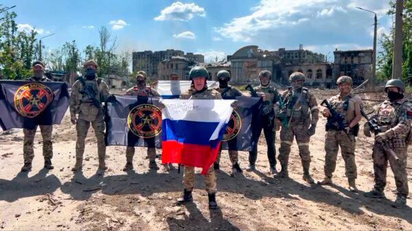 Yevgeny Prigozhin, the head of the Wagner Group military company, holds a Russian national flag in front of his soldiers in Bakhmut, Ukraine, in a still from video released on May 20, 2023. (Prigozhin Press Service via AP)