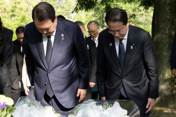 South Korean President Yoon Suk-yeol (L) and Japanese Prime Minister Fumio Kishida bow as they lay flowers at the Monument in Memory of the Korean Victims of the 1945 atomic bombing near the Peace Park Memorial in Hiroshima, western Japan, on May 21, 2023, on the sidelines of the G-7 Summit. (Yuichi Yamazaki/Pool Photo via AP)