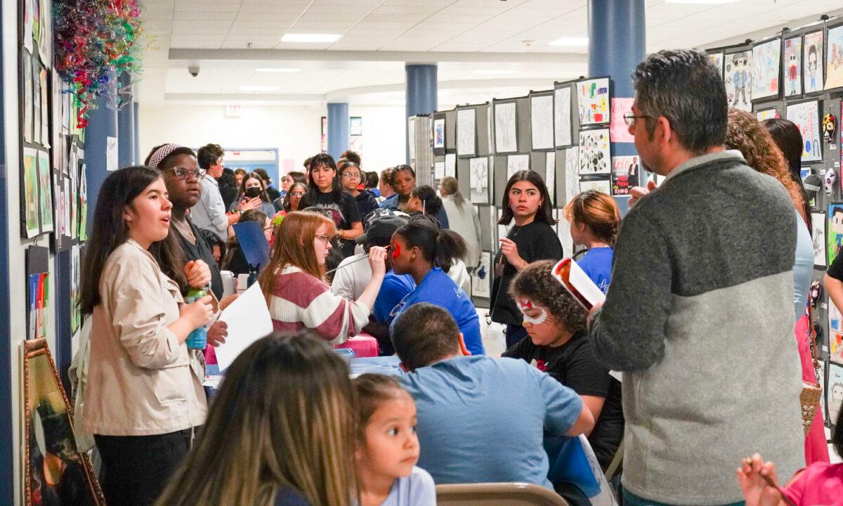 Residents gather around the art sections during the annual community event at Middletown High School in Middletown, N.Y., on May 19, 2023. (Cara Ding/The Epoch Times)