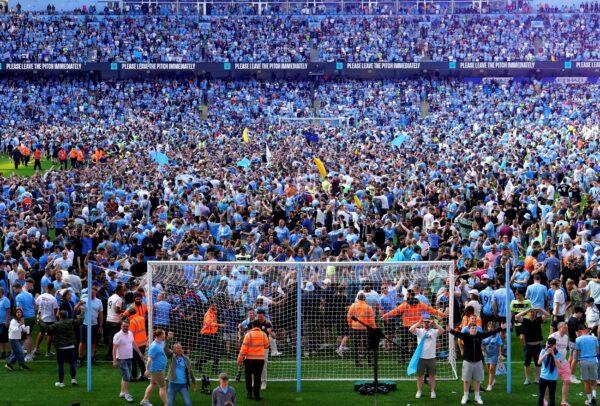 Manchester City fans invade the pitch as they celebrate their English Premier League title win at the end of the English Premier League soccer match between Manchester City and Chelsea at the Etihad Stadium in Manchester, England, on May 21, 2023. (Martin Rickett/PA via AP)