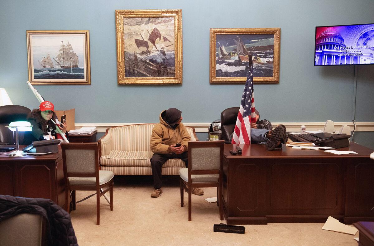 Megan Paradise (left) sits adjacent to Richard "Bigo" Barnett (R) inside the office of House Speaker Nancy Pelosi (D-Calif.) on Jan. 6, 2021. (U.S. Department of Justice/Screenshot via The Epoch Times)