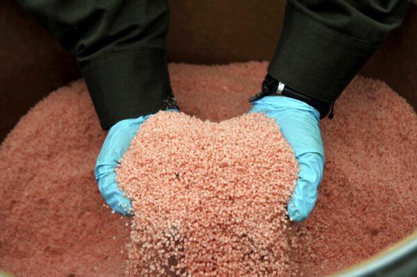 A Colombian police officer shows part of one ton of ANFO (Ammonium Nitrate-Fuel Oil) explosive seized in Cali, Colombia, on July 29, 2010. (LUIS ROBAYO/AFP via Getty Images)