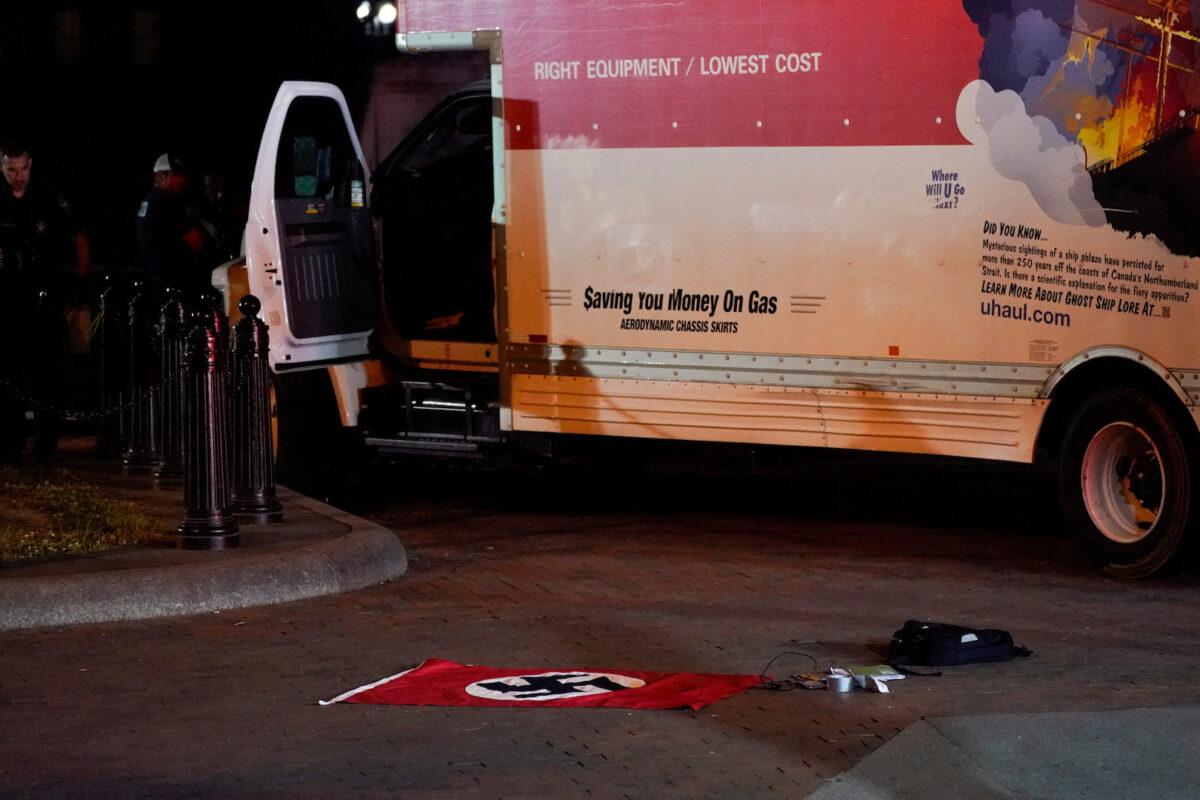 A Nazi-style flag and other objects recovered from a rented box truck are pictured on the ground as the U.S. Secret Service and other law enforcement agencies investigate the truck that crashed into security barriers at Lafayette Park across from the White House in Washington on May 23, 2023. (Nathan Howard/Reuters)