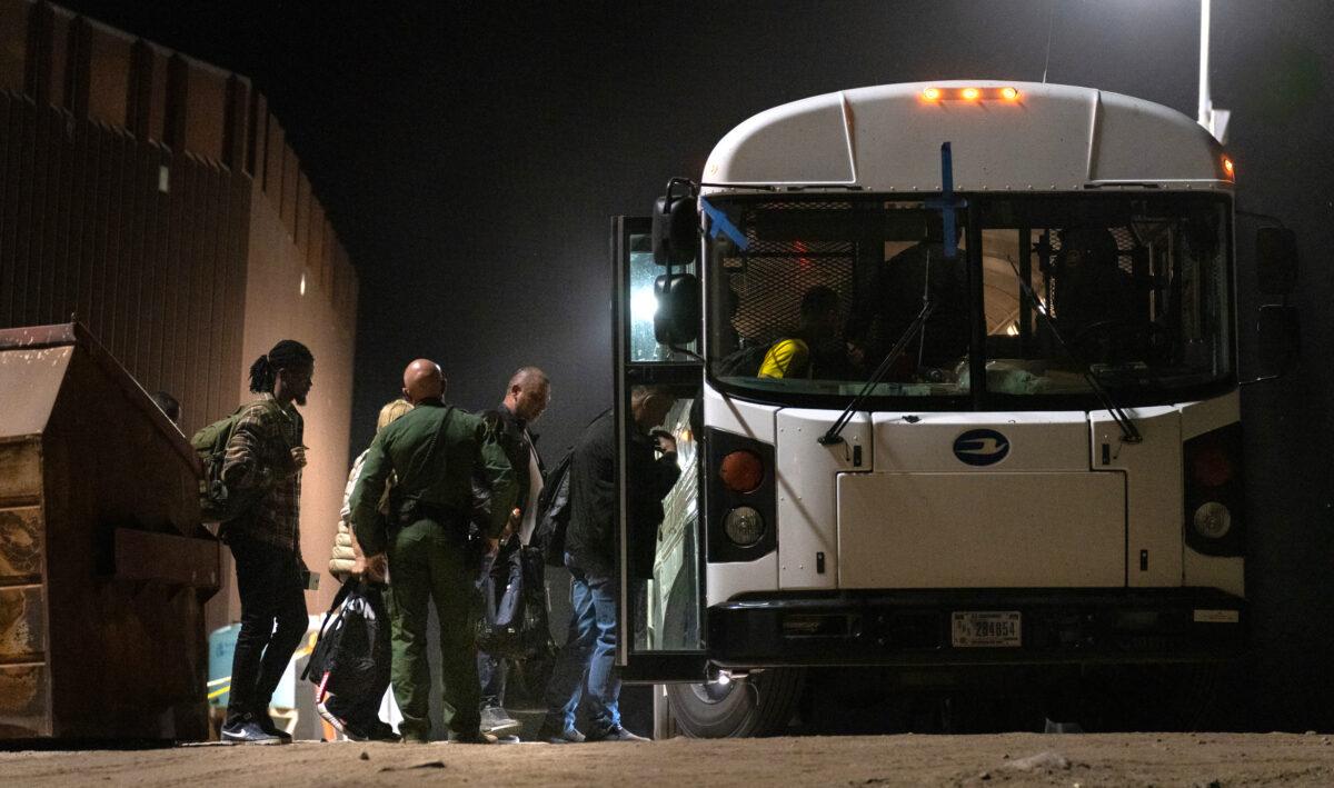 Illegal immigrants prepare to be transported by bus to processing facilities in Yuma, Ariz., on May 18, 2023. (John Fredricks/The Epoch Times)