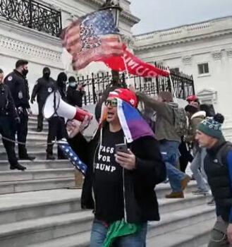 Jan. 6 defendant Eric Christie carried a bullhorn at the bottom of the east steps of the U.S. Capitol on Jan. 6, 2021. (U.S. Department of Justice/Screenshot via The Epoch Times)