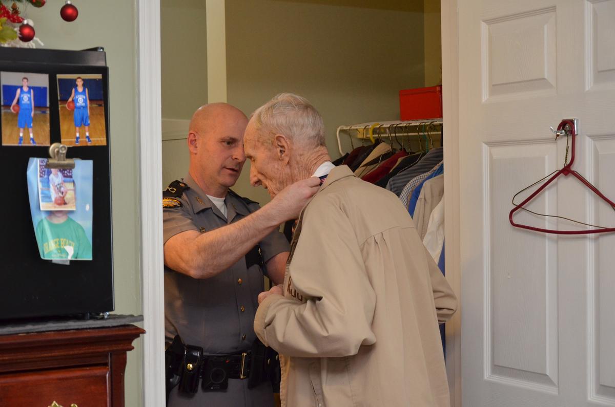 Kentucky state trooper Jonathan McChesney helps centenarian Edwin Smith with his tie before his birthday celebration in Barren County, Ky. (Tracey Sharber)