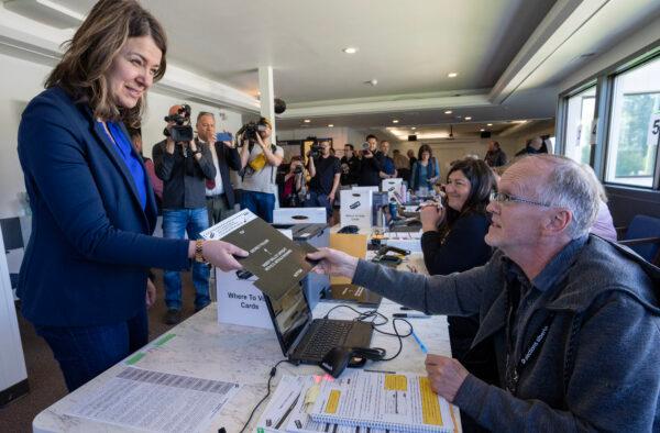 Alberta UCP Leader Danielle Smith receives her ballot to vote at an advance voting station for the upcoming provincial election in Calgary on May 23, 2023. (The Canadian Press/Todd Korol)