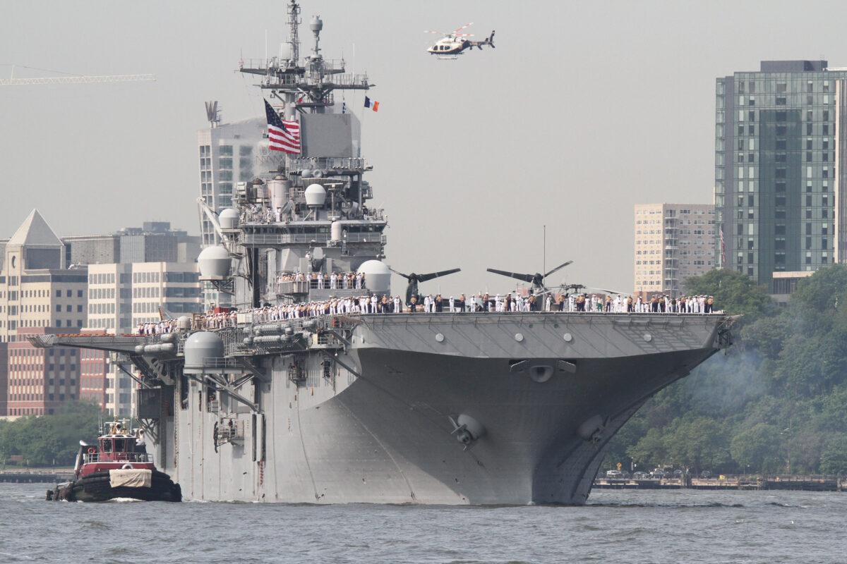 USS Wasp, its crew at attention along the railings, heads toward its berth on the Hudson River to take part in the 35th Annual Fleet Week in New York on May 23, 2023. (Richard Moore/The Epoch Times)
