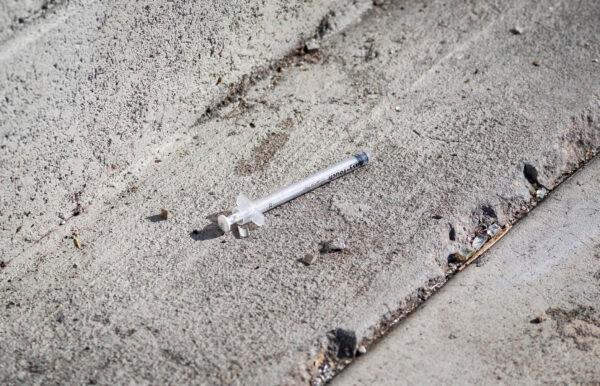 A used syringe lays disgarded on a sidewalk outside of downtown Los Angeles on Jan. 21, 2022. (John Fredricks/The Epoch Times)