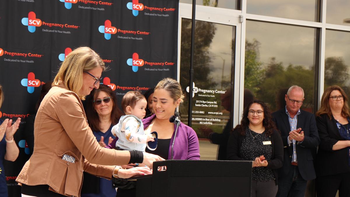  A patient of the Santa Clarita Valley Pregnancy Center, holding her son, speaks during a press conference in Santa Clarita, Calif., on May 24, 2023. (Courtesy of California Family Council)