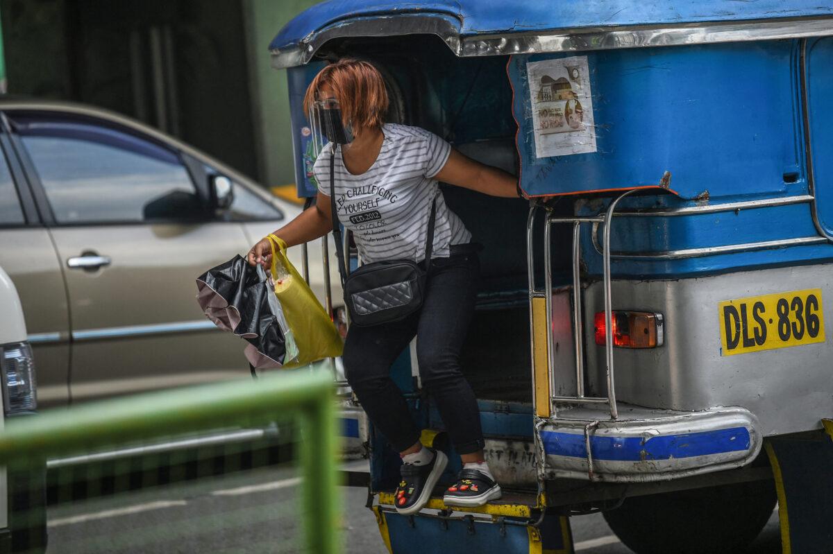 A passenger disembarks from a jeepney on a street in Manila on Sept. 7, 2021. (Ted Aljibe/AFP via Getty Images)