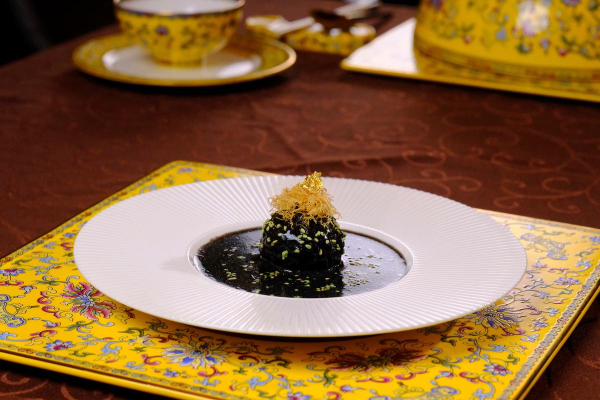 'Black Gold' lion's head meatballs are enriched with salted egg yolks, dyed with cuttlefish ink, and garnished with edible gold. (Courtesy of Chef Guo)