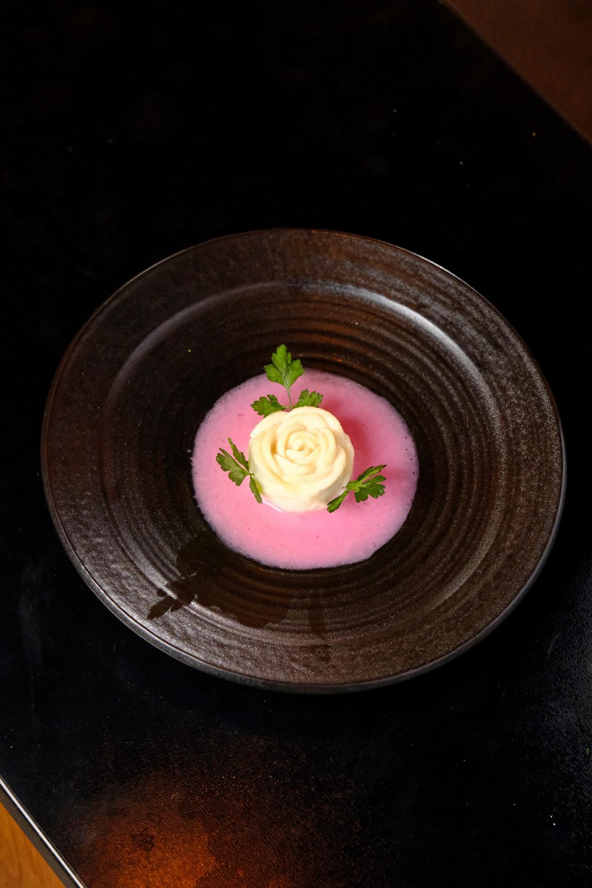 A peony flower made with prawn and fish is set in a dragonfruit juice-tinged broth. (Courtesy of Chef Guo)