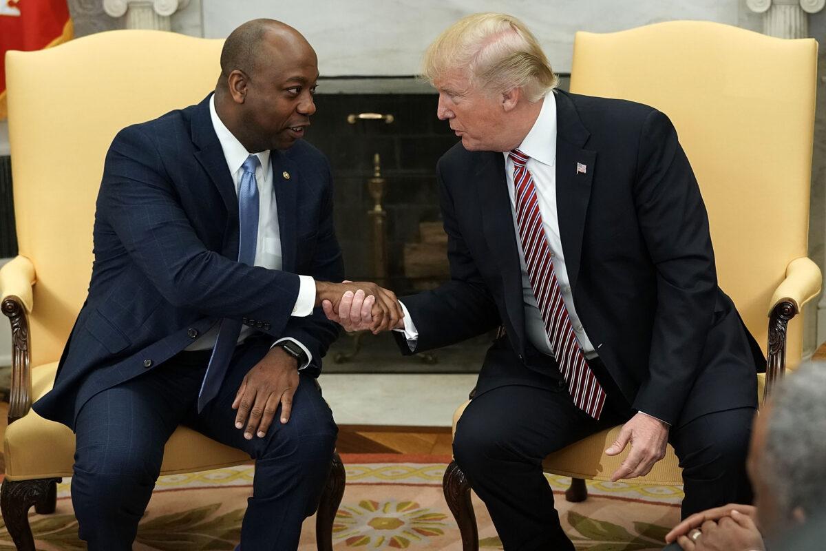 The then President Donald Trump shakes hands with Sen. Tim Scott (R-S.C.) during a working session regarding the Opportunity Zones provided by tax reform in the Oval Office of the White House on Feb. 14, 2018. (Alex Wong/Getty Images)