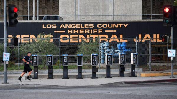 A man jogs past a row of telephone booths in front of the Los Angeles County Men's Central Jail on May 11, 2020. (Frederic J. Brown/AFP via Getty Images)