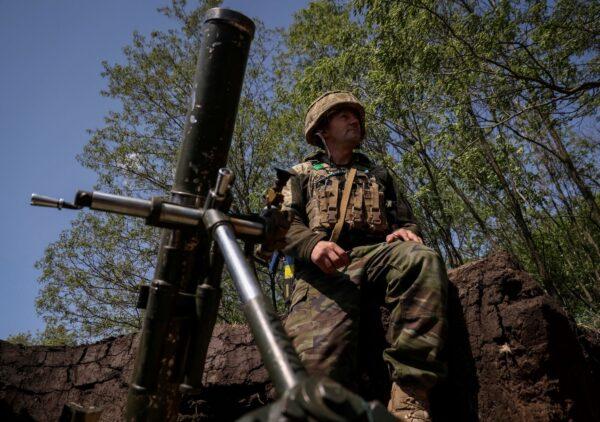 A Ukrainian service member prepares to fire a mortar from his position at a front line near the city of Bakhmut in Donetsk, Ukraine, on May 18, 2023. (Sofiia Gatilova/Reuters)