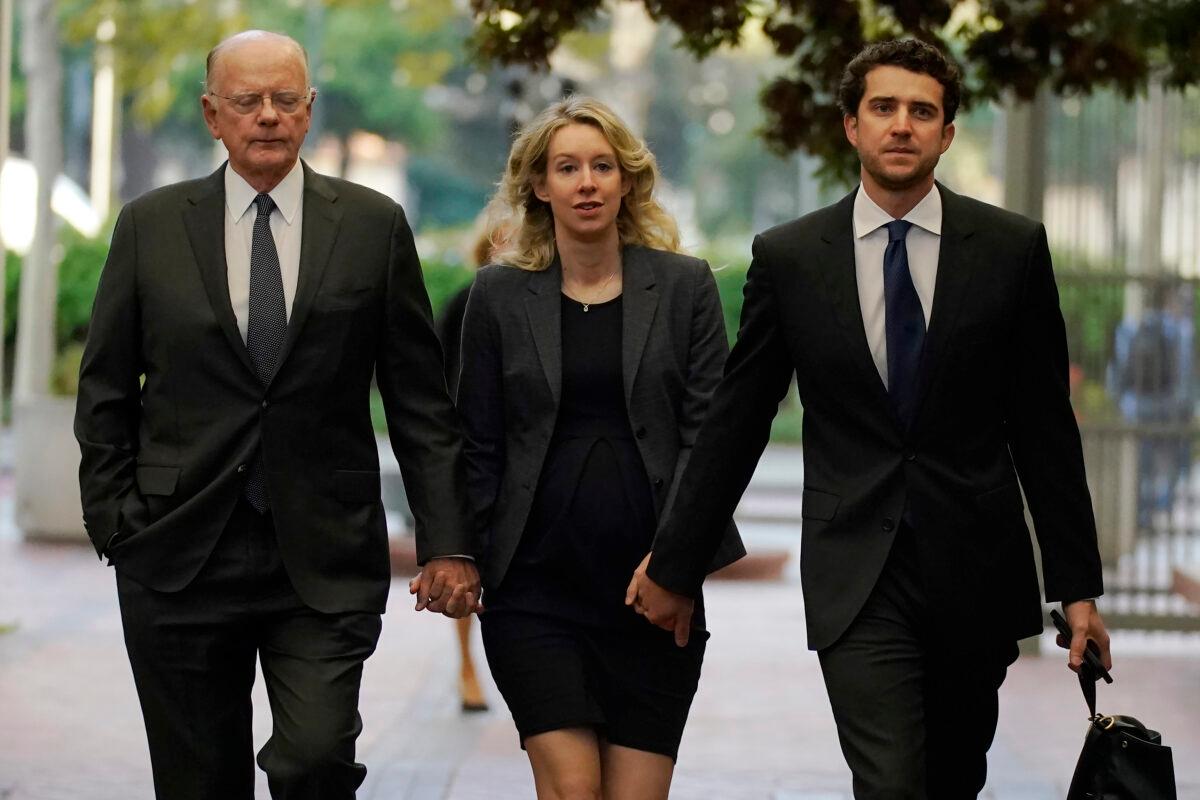 Former Theranos CEO Elizabeth Holmes (C) arrives at federal court with her father, Christian Holmes IV (L) and partner, Billy Evans, in San Jose, Calif., on Oct. 17, 2022. (Jeff Chiu/AP Photo)