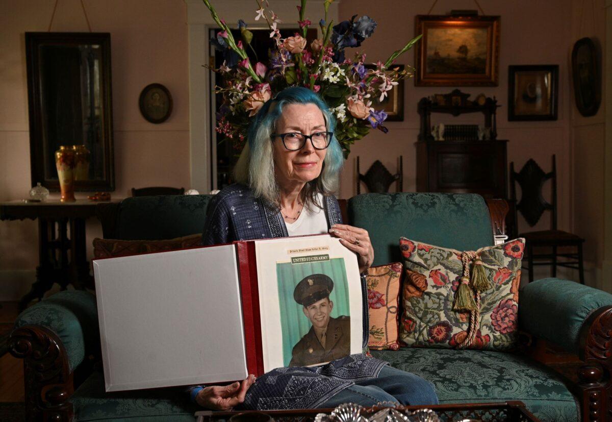 Portrait of Judy Wade, niece of Luther Story, with memory scrapbook of Luther Story, that her mother put together, in Americus, Ga., on May 18, 2023. (Hyosub Shin/Atlanta Journal-Constitution via AP)