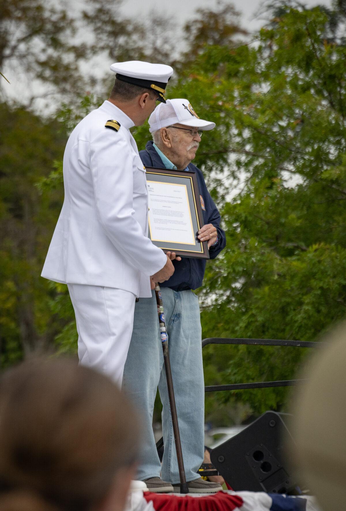 World War II Veteran Robert Reed accepts recognition for his service on stage at Memorial Day celebrations in Fairhaven Memorial Park in Santa Ana, Calif., on May 29, 2023. (John Fredricks/The Epoch Times)