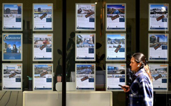 People walk past a real estate agent's window in Melbourne, Australia, on March 7, 2023. (William West/AFP via Getty Images)