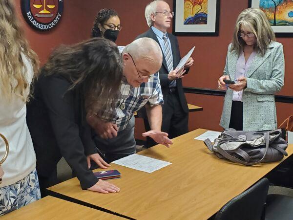 Jeff Titus and attorney Mary Chartier look at the paperwork that closed the double murder case against Titus. (Marie Weidmayer/Kalamazoo Gazette via AP)