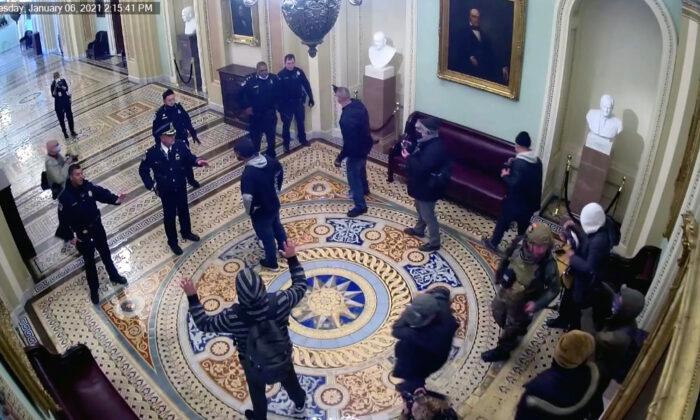 The first protesters to breach the U.S. Capitol confront police at 2:15 p.m. on Jan. 6, 2021. (U.S. Capitol Police/Screenshot via The Epoch Times)