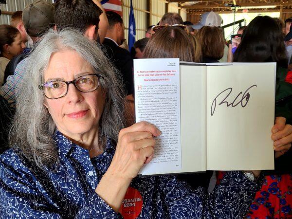 Frances Bouton, a supporter of Florida Gov. Ron DeSantis's campaign for president, got his autograph on her copy of his book at his campaign stop in Gilbert, S.C., on June 2, 2023. (Dan M. Berger/The Epoch Times)