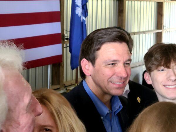 Florida Gov. Ron DeSantis, a Republican candidate for president, poses for a photo with a supporter at a campaign stop in Gilbert, S.C. ,on June 2, 2023. (Dan M. Berger/The Epoch Times)